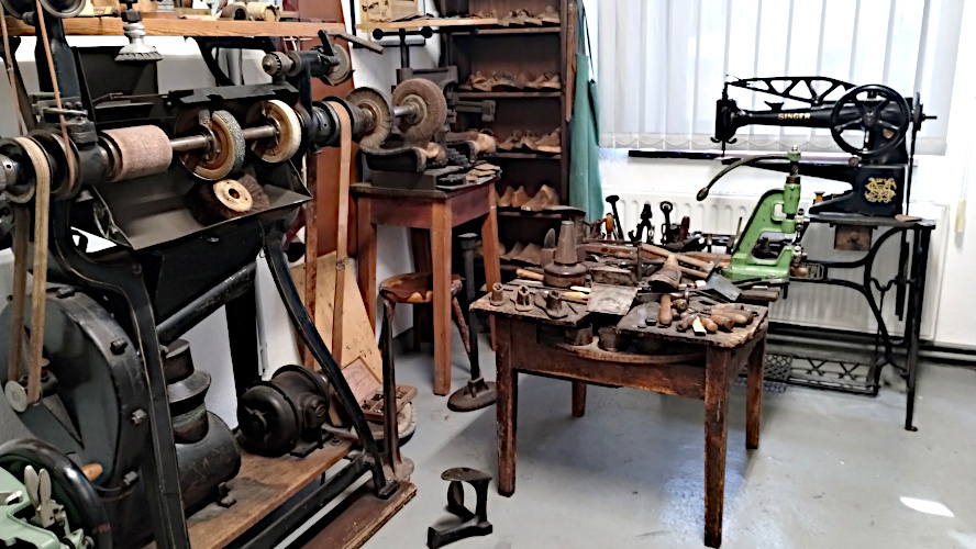 Man sieht z.B. mehere Leisten (Holz- oder Metallformen, die einen Fuß ähneln) und verschiedene Werkzeuge des Schuhmachers, z.B. Hammer, Ahle Beißzange (zum Herausziehen der Zwicknägel).